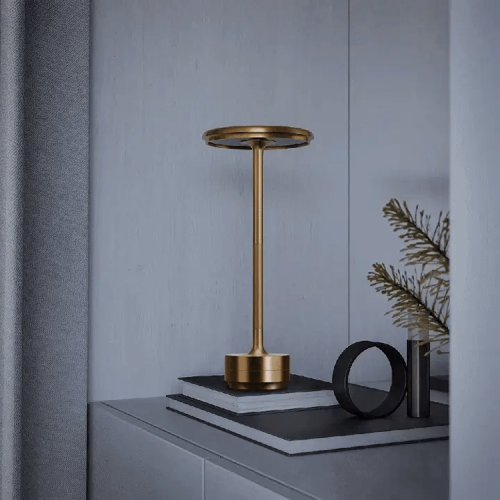 Gold lamp on a dark surface with a gray wall background